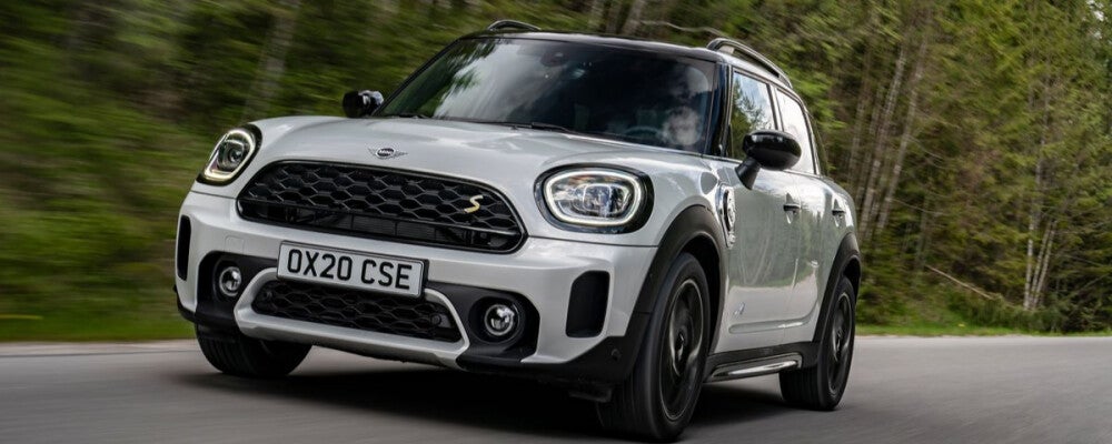 2022 White Mini Cooper Countryman driving on highway surrounded by trees