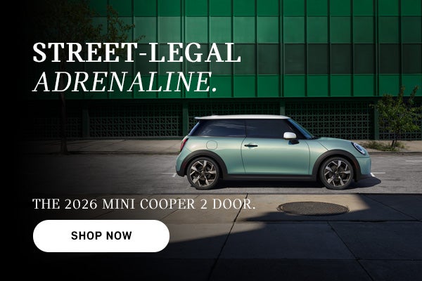 Mint green MINI Cooper 2-door parked on a city street with building backdrop, with ad text promoting the 2026 model.