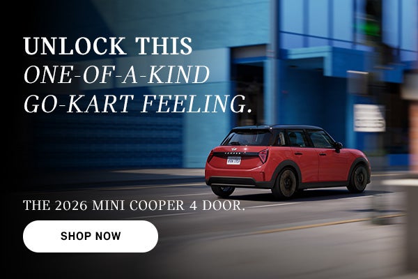 Red MINI Cooper 4-door driving on a city street, with motion blur in the background and ad text promoting the 2026 model and 