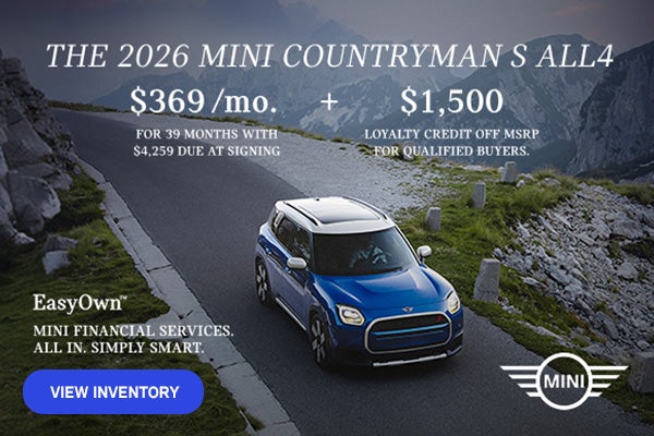 Front view of a blue MINI Countryman driving on a mountainous road.