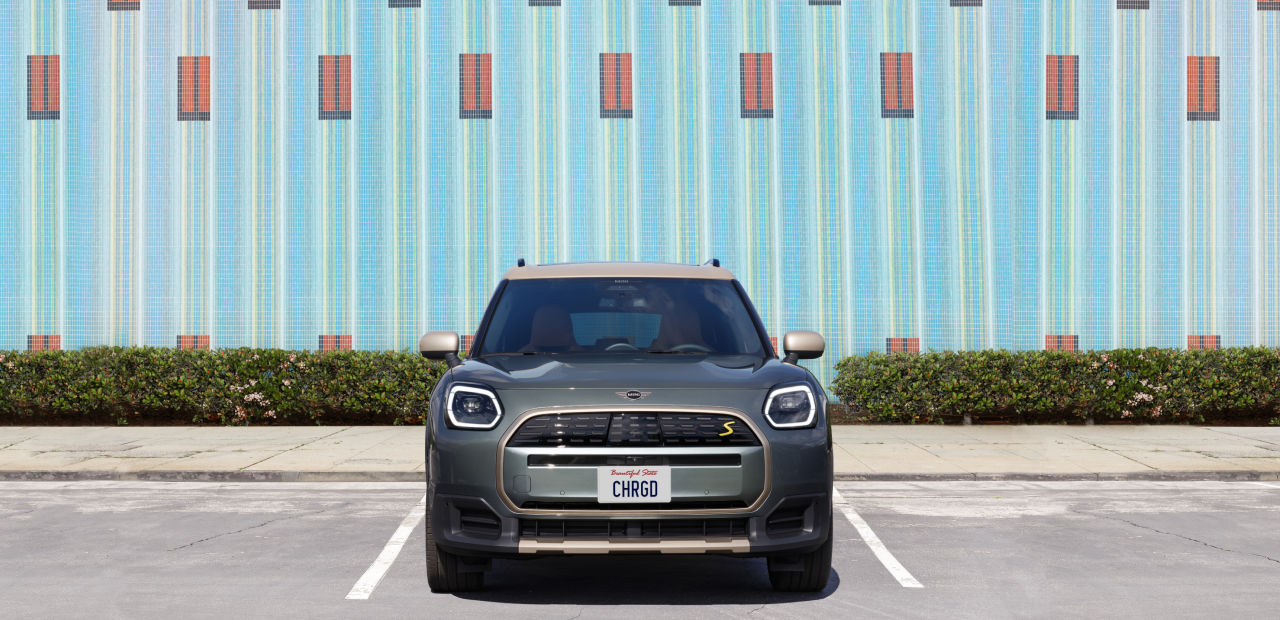 Front view of the MINI Countryman SE ALL4 parked in front of a tile building. 