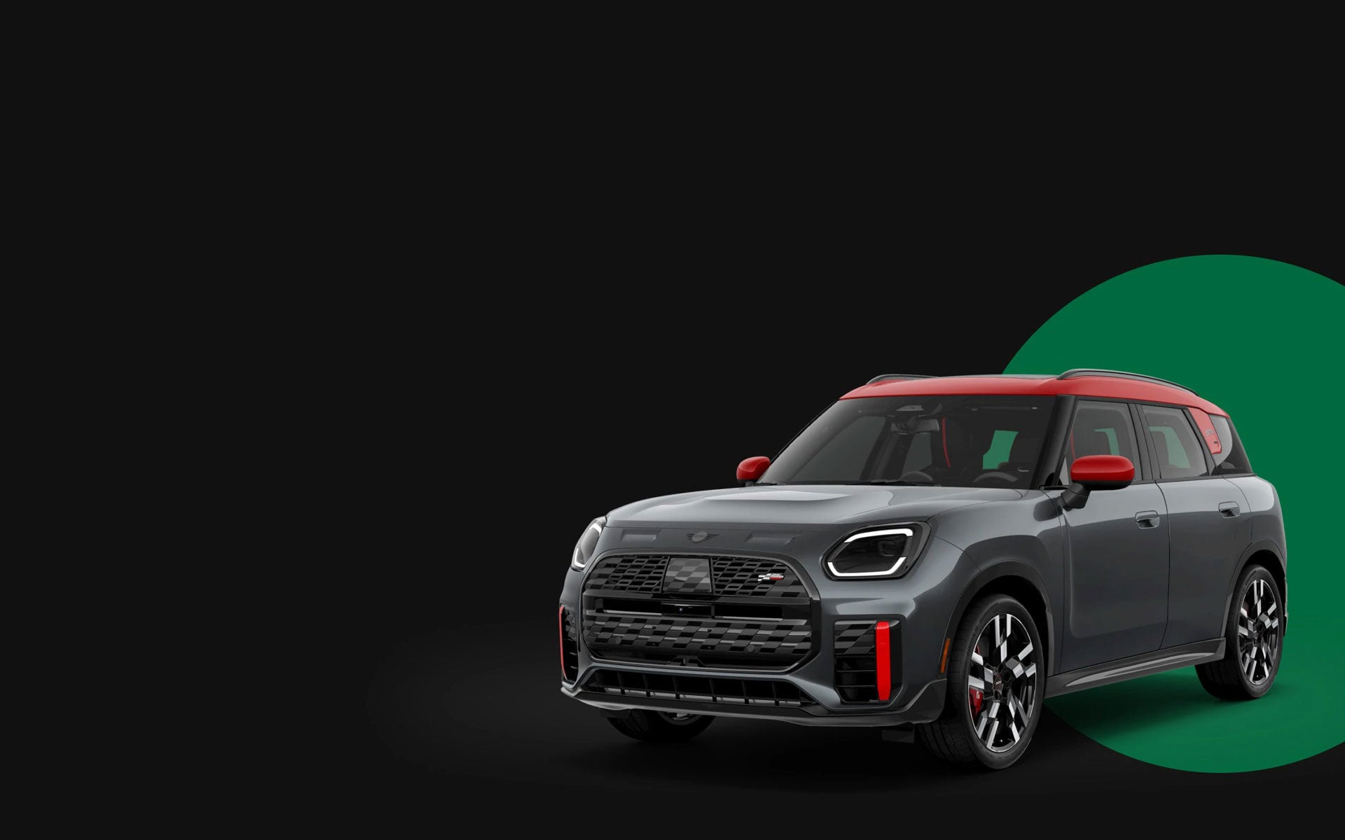 Angled front-to-rear view of the MINI JCW Countryman ALL4 in front of a green circle with a black background.