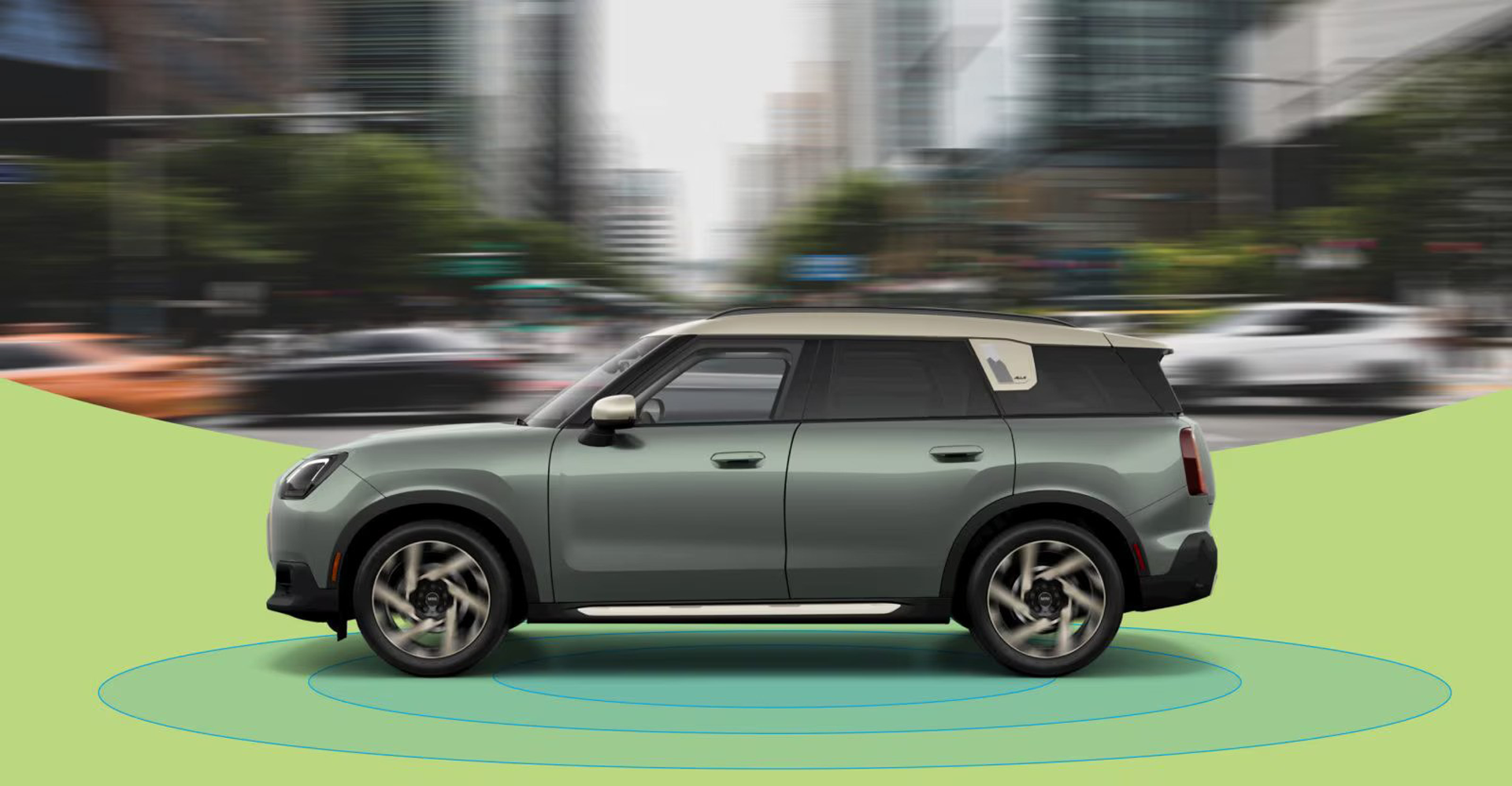 The side-view of a 2025 MINI Countryman S ALL4 with a blurred city street in the background and blue rings beneath it.