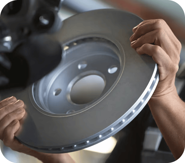 Closeup view of hands holding a circular piece of metal with the background blurred out.