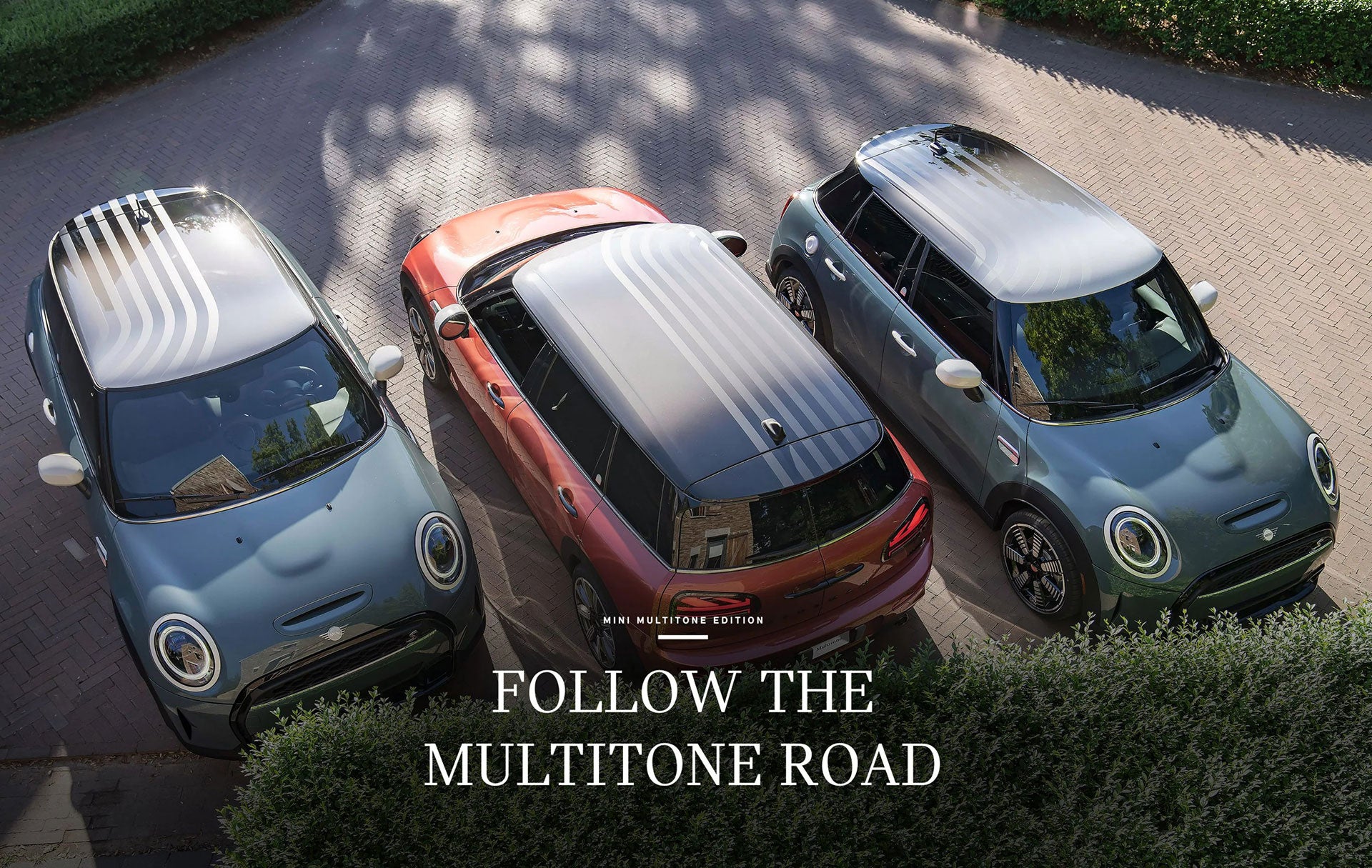 Three MINI Multitone Edition cars in Sage Green and Coral Red parked side by side on a brick surface.